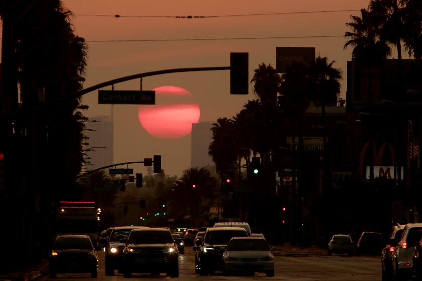 LOS ANGELES, CA - AUG. 18, 2020. The sun sets on Whittier Boulevard in East Los Angeles, which has served as a hub of Latino life, commerce and culture for decades. The affordable shopping district and surrounding neighborhoods was fertile ground for an emerging, immigrant-rich middle class. Today, the heart of Whittier Blvd., from Atlantic Avenue on the west to Eastern Avenue on the east, is facing a new host of challenges from the coronavirus pandemic, economic meltdown and creeping gentrification. For many, this faded but resilient avenue remains a crossroads of change and hope. (Luis Sinco / Los Angeles Times)