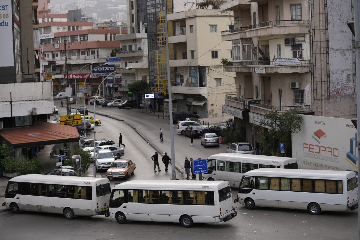 Public transport buses block a road, during a general strike by public transport and labor unions to protest the country's deteriorating economic and financial conditions in Beirut, Lebanon, Thursday, Jan. 13, 2022. Protesters closed the country's major highways as well as roads inside cities and towns starting 5 a.m. making it difficult for people to move around. (AP Photo/Hussein Malla)