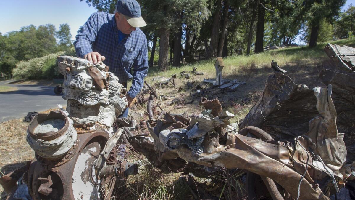 Property developer Phil Boczanowski with some of the wreckage of a Navy plane that crashed in a World War II training accident that still lies on Palomar Mountain. A memorial was erected at the site in January.