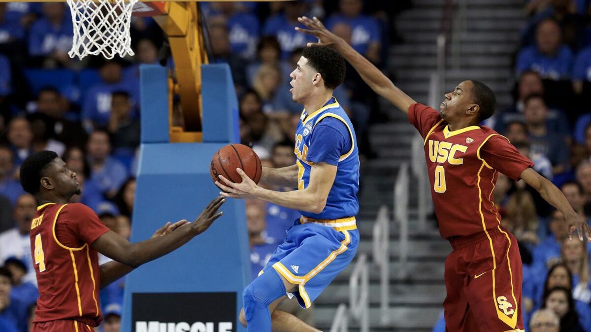 UCLA's Lonzo Ball, center, drives to the basket guarded by USC's Chimezie Metu, left, and Shaqquan Aaron on February 18.