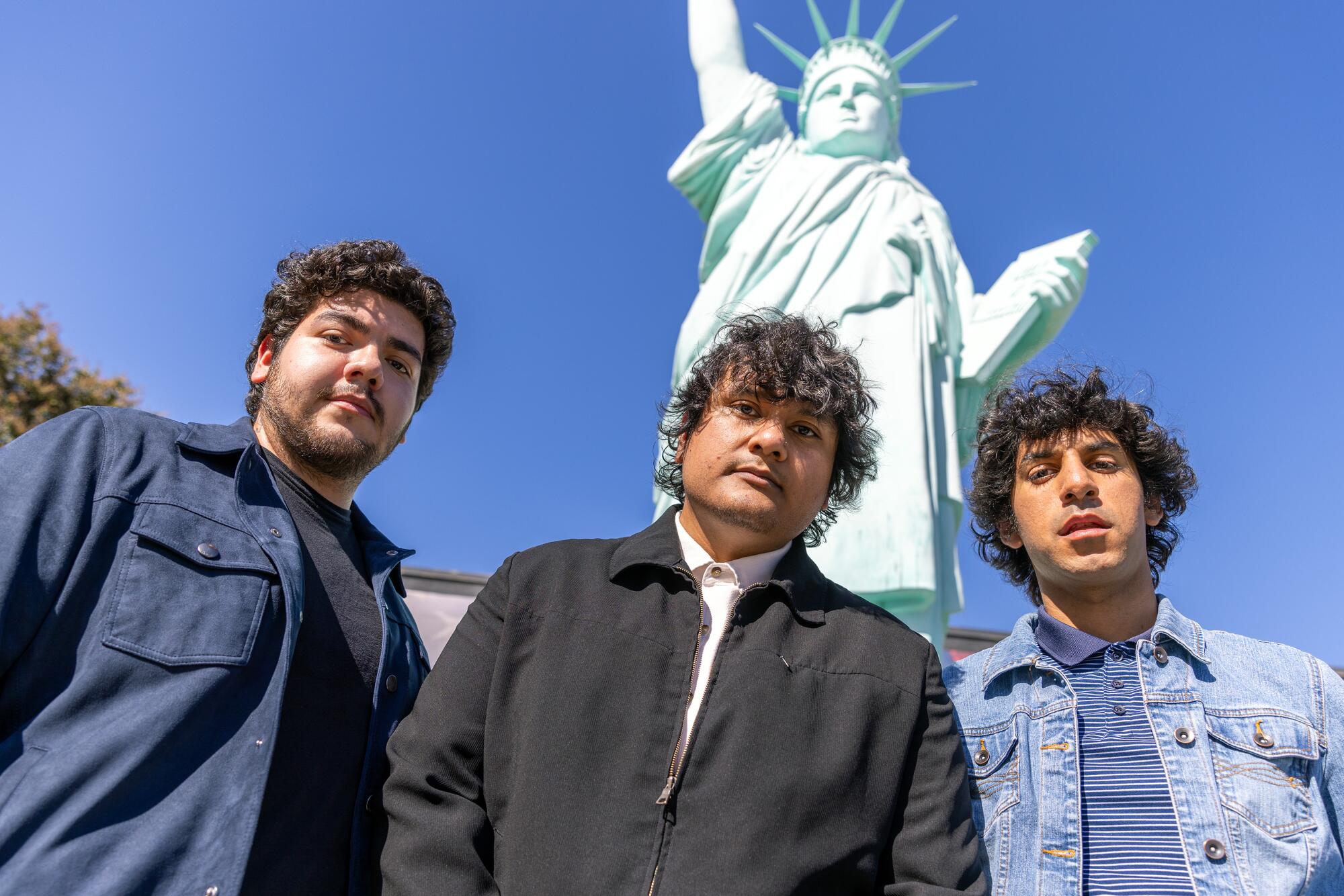 From left, Patrick Juarez, Henry Vargas, and Jose Corona pose in front of the Statue of Liberty Replica in El Monte.