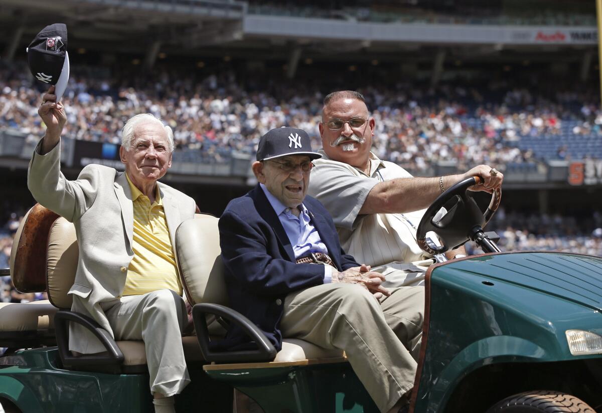 Whitey Ford, left, tips his cap as he and former teammate Yogi Berra are introduced during the Yankees' 2014 Old-Timers Day.