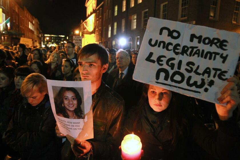 Protesters in Dublin hold pictures of Savita Halappanavar as they gather outside the Irish Parliament building Nov. 14 during a demonstration in favor of abortion legislation.