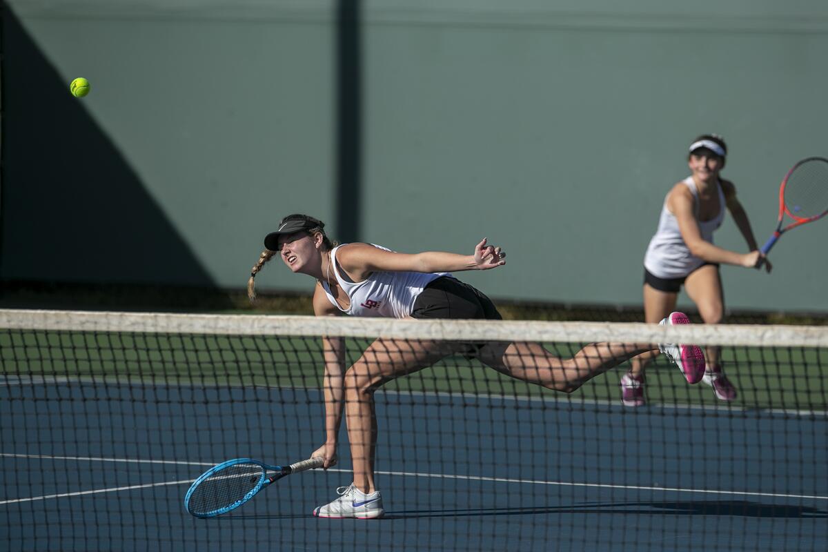 Laguna Beach's Ella Pachl, left, returns a shot at the net as her partner, Sarah MacCallum, watches in the CIF Southern Section Individuals doubles title match against Beckman's Kiki Nguyen and Victoria Aguirre on Dec. 9 at Seal Beach Tennis Center.