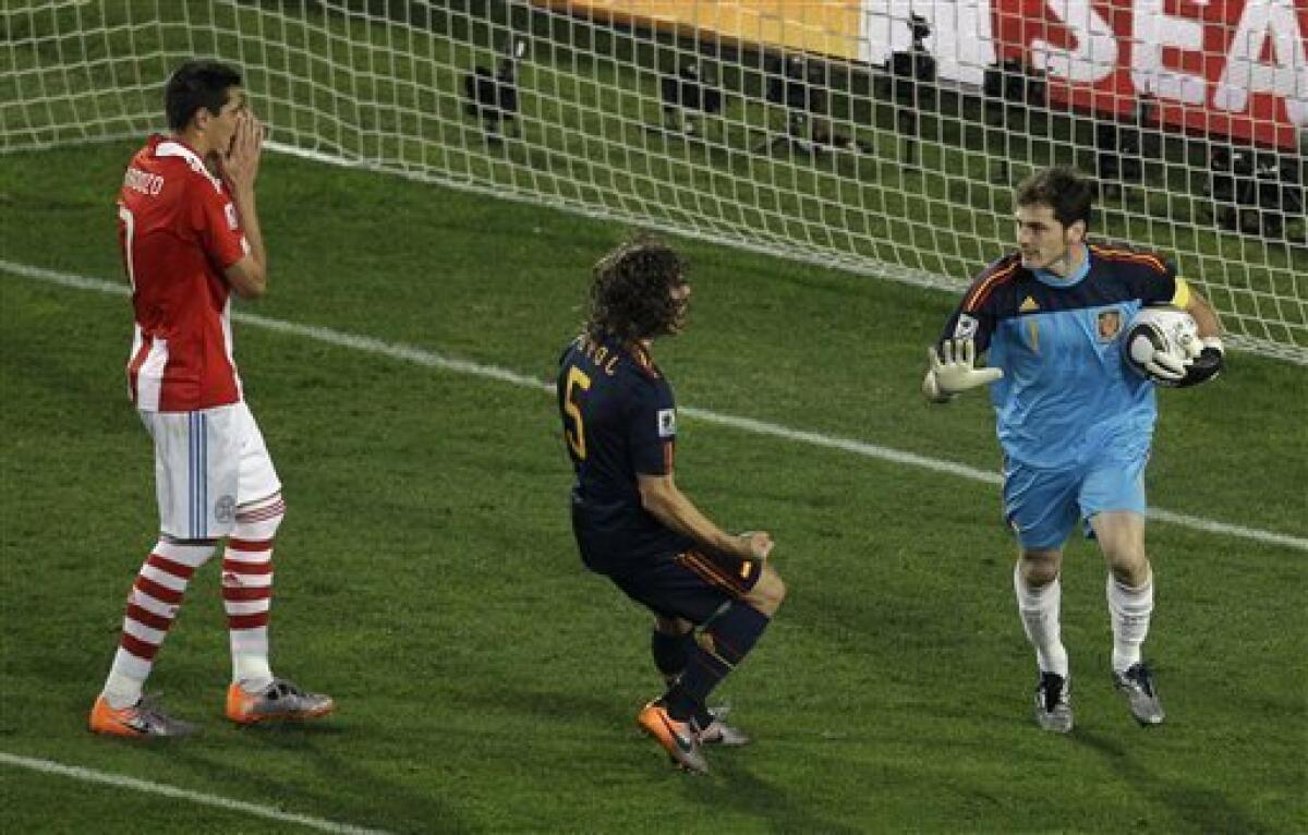 Paraguay's Oscar Cardozo, left, reacts after missing a penalty kick as Spain goalkeeper Iker Casillas, right, picks up the ball during the World Cup quarterfinal soccer match between Paraguay and Spain at Ellis Park Stadium in Johannesburg, South Africa, Saturday, July 3, 2010. (AP Photo/Themba Hadebe)