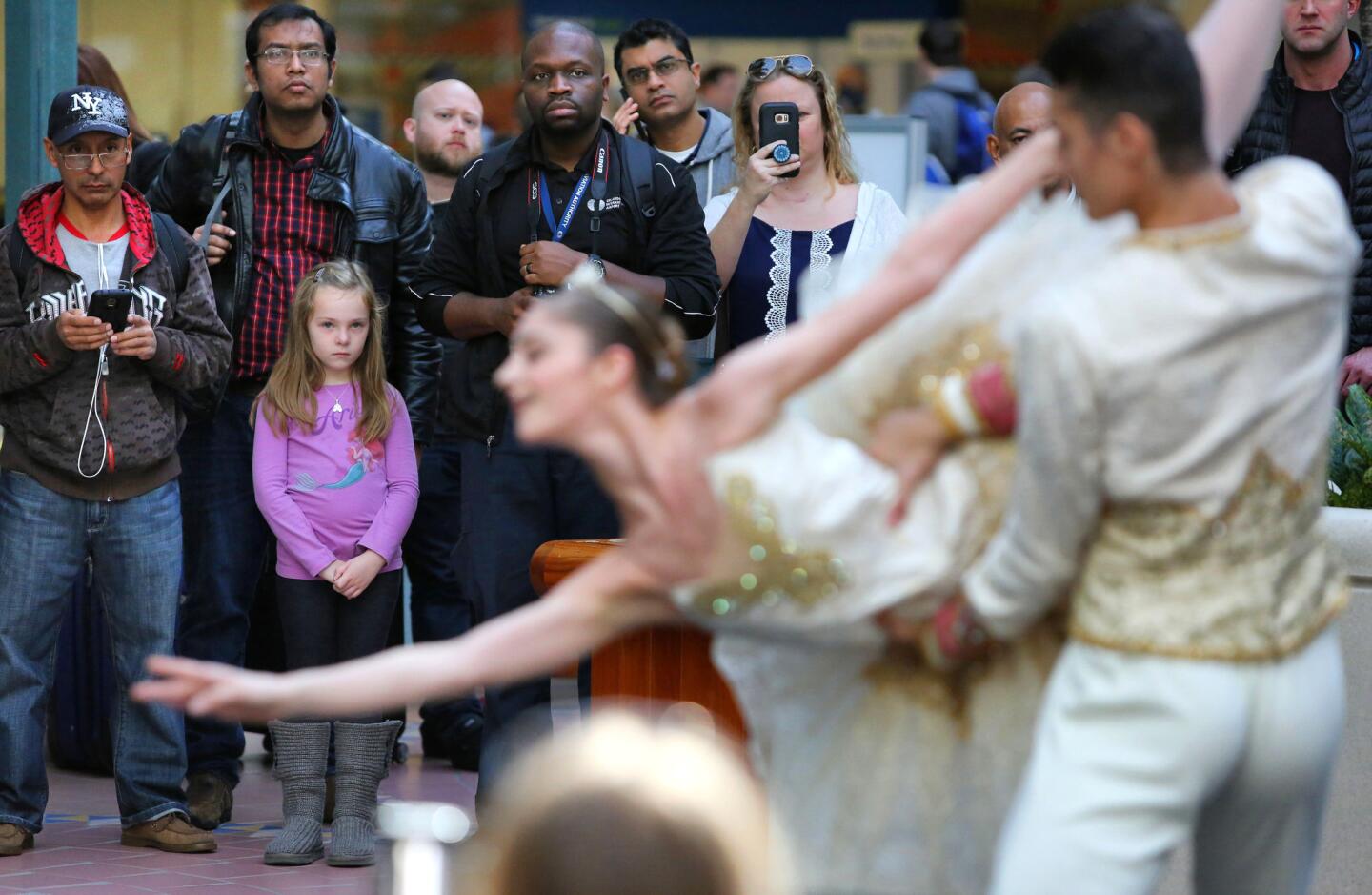 Travelers watch Israel Zavaleta and Cara Bell dance as members of the Orlando Ballet perform exerpts from The Nutcracker during a mini-performance in the Hyatt Hotel concourse at Orlando International Airport, Thursday, December 14, 2017. The ballet is one of the artistic endeavors that OIA brings in during the holidays to cheer up weary travelers. (Joe Burbank/Orlando Sentinel) 3030070