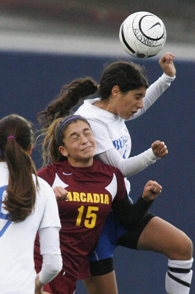 Burbank's Zana Hundal jumps higher to head the ball against Arcadia's Vienna Rousset in the first half in a Pacific League girls soccer match at Burbank High School on Friday, February 25, 2013.