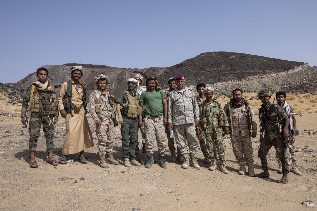 Maj. Gen. Nasser al-Dhaibani, who headed military operations of the government's armed force, sixth from right in red beret, poses for a photograph with fighters backed by the Saudi-led coalition, near the Kassara frontline with Houthi fighters, near Marib, Yemen, June 20, 2021. On Monday, Dec. 13, 2021, officials said al-Dhaibani died in clashes between Yemeni government forces and the country's Houthi rebels. The development is a big blow to the forces of Yemen's internationally recognized government, who have been fighting for months against the Iranian-backed Houthis’ attempt to take Marib. (AP Photo/Nariman El-Mofty)