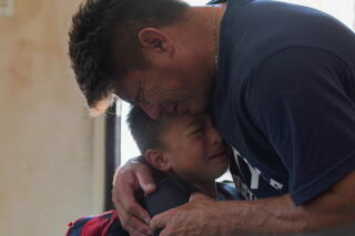Jesus Cruz hugs his son Gabriel as they say goodbye