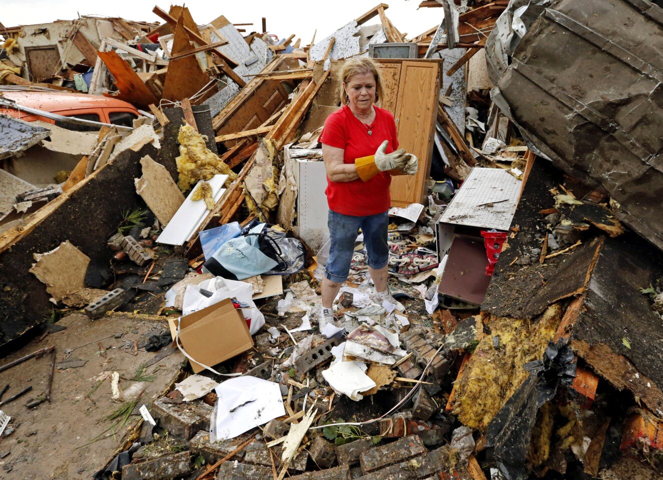 JoAnn Anderson sorts through the rubble of her home after a tornado in Moore, Okla.