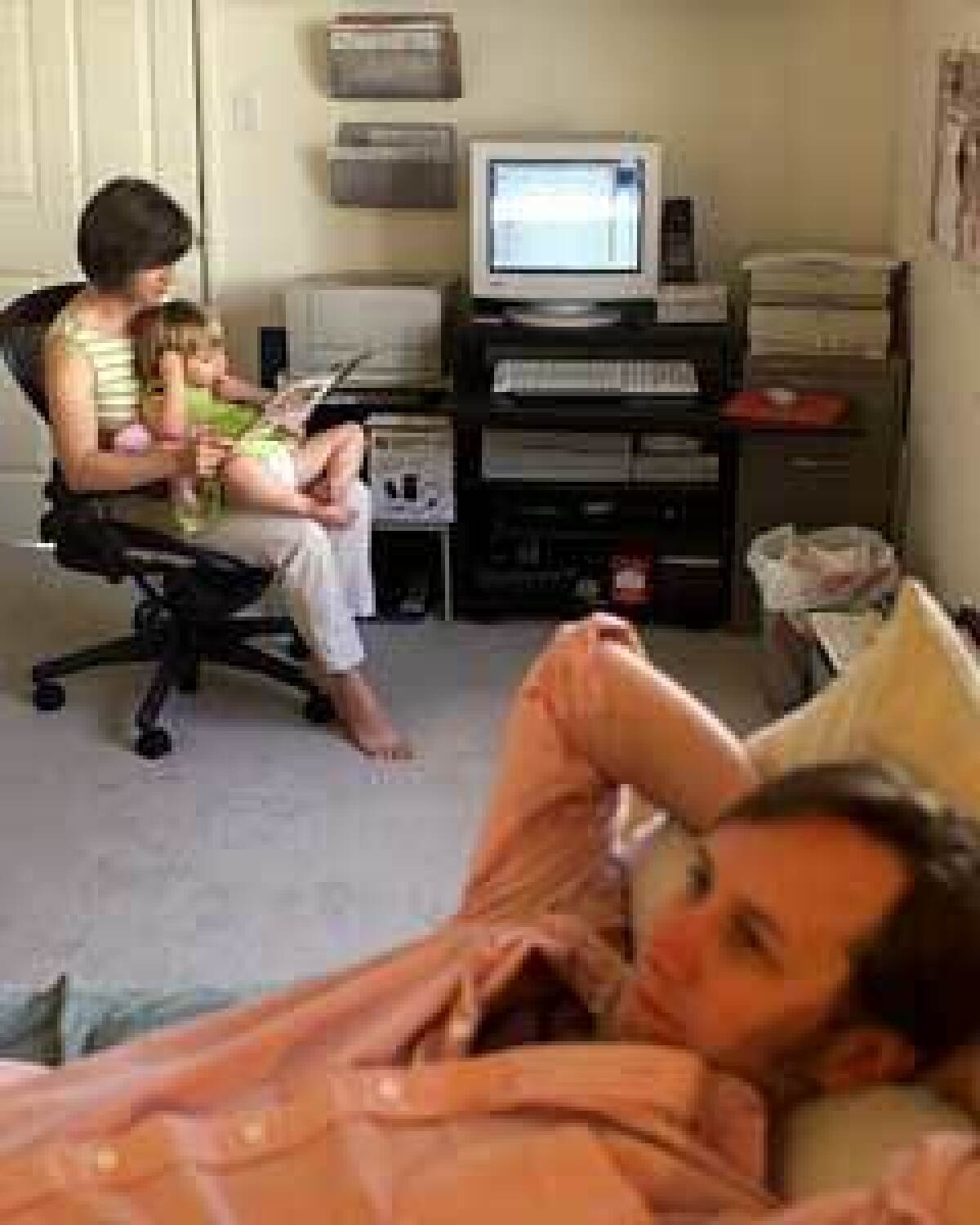 Paul Trautwein relaxes with wife Mary Beth and daughter Edith in the bedroom, which doubles as Paul's office.