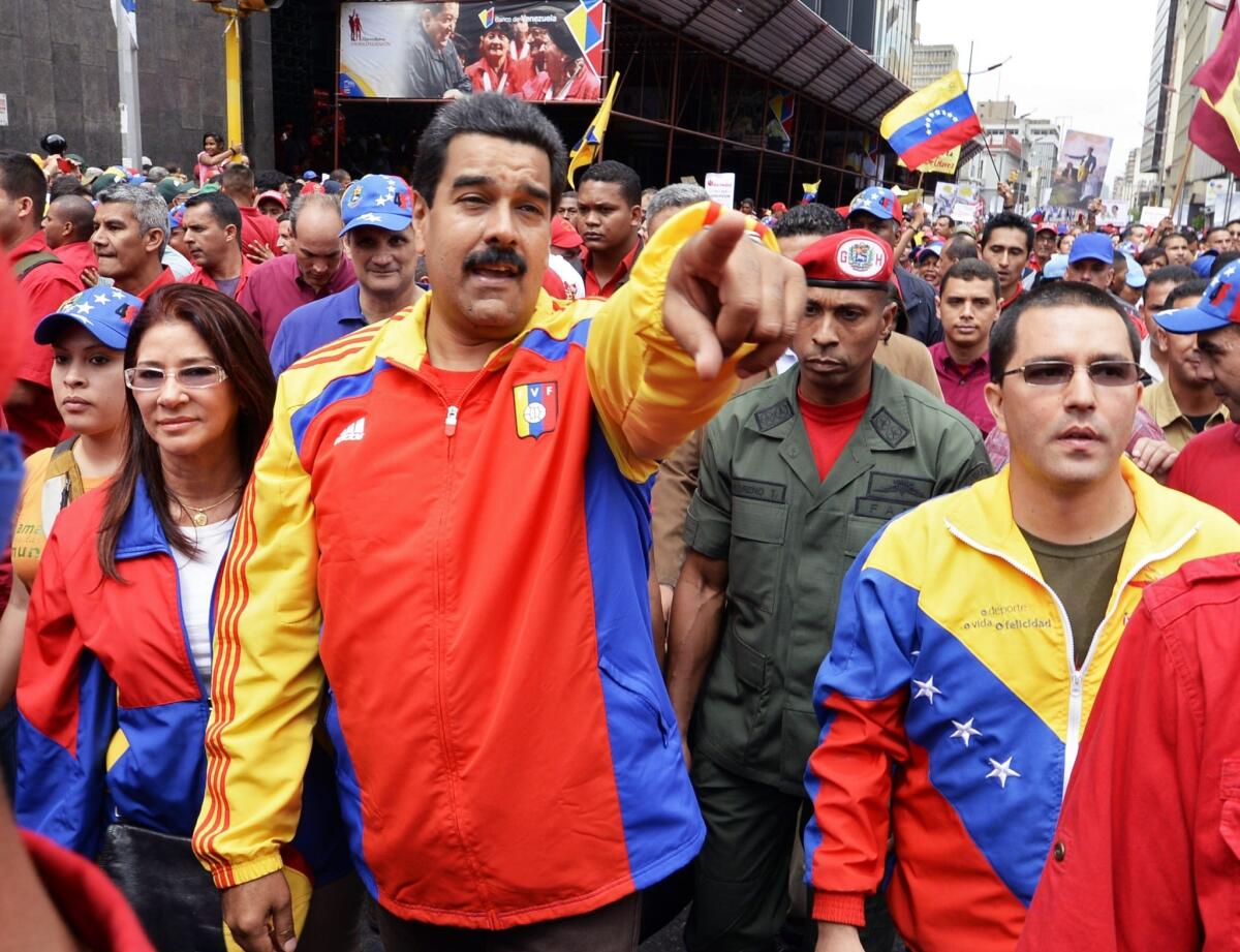 Venezuelan Vice President Jorge Arreaza, right, President Nicoals Maduro, center, and First Lady Cilia Flores, left, lead a demonstration in Caracas on Aug. 3 against corruption.