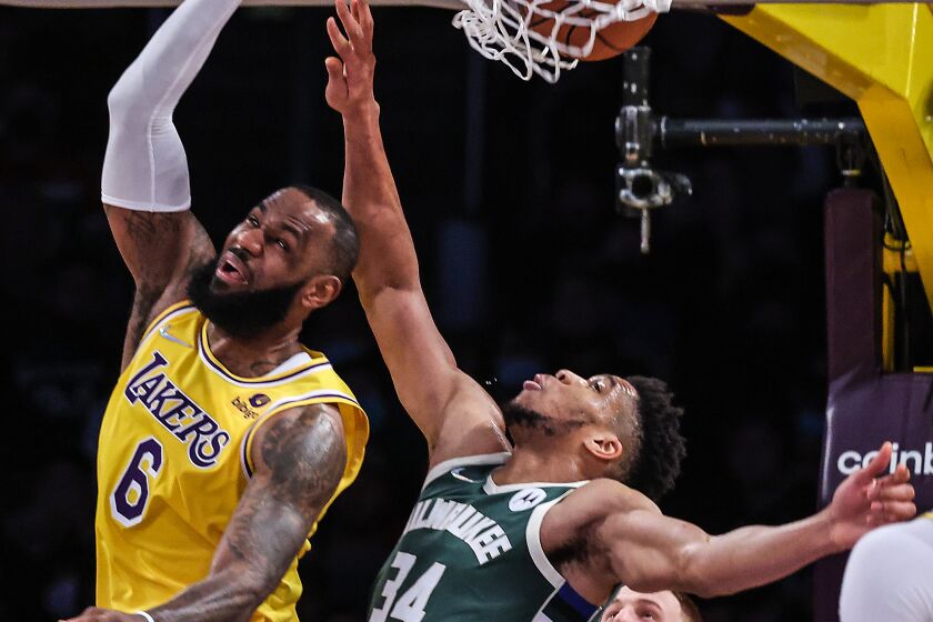 Lakers forward LeBron James (6) slam dunks over Milwaukee Bucks forward Giannis Antetokounmpo.