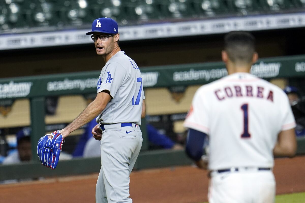 Los Angeles Dodgers relief pitcher Joe Kelly (17) looks back at Houston Astros' Carlos Correa (1) after the sixth inning of a baseball game Tuesday, July 28, 2020, in Houston. Both benches emptied during the exchange. (AP Photo/David J. Phillip)