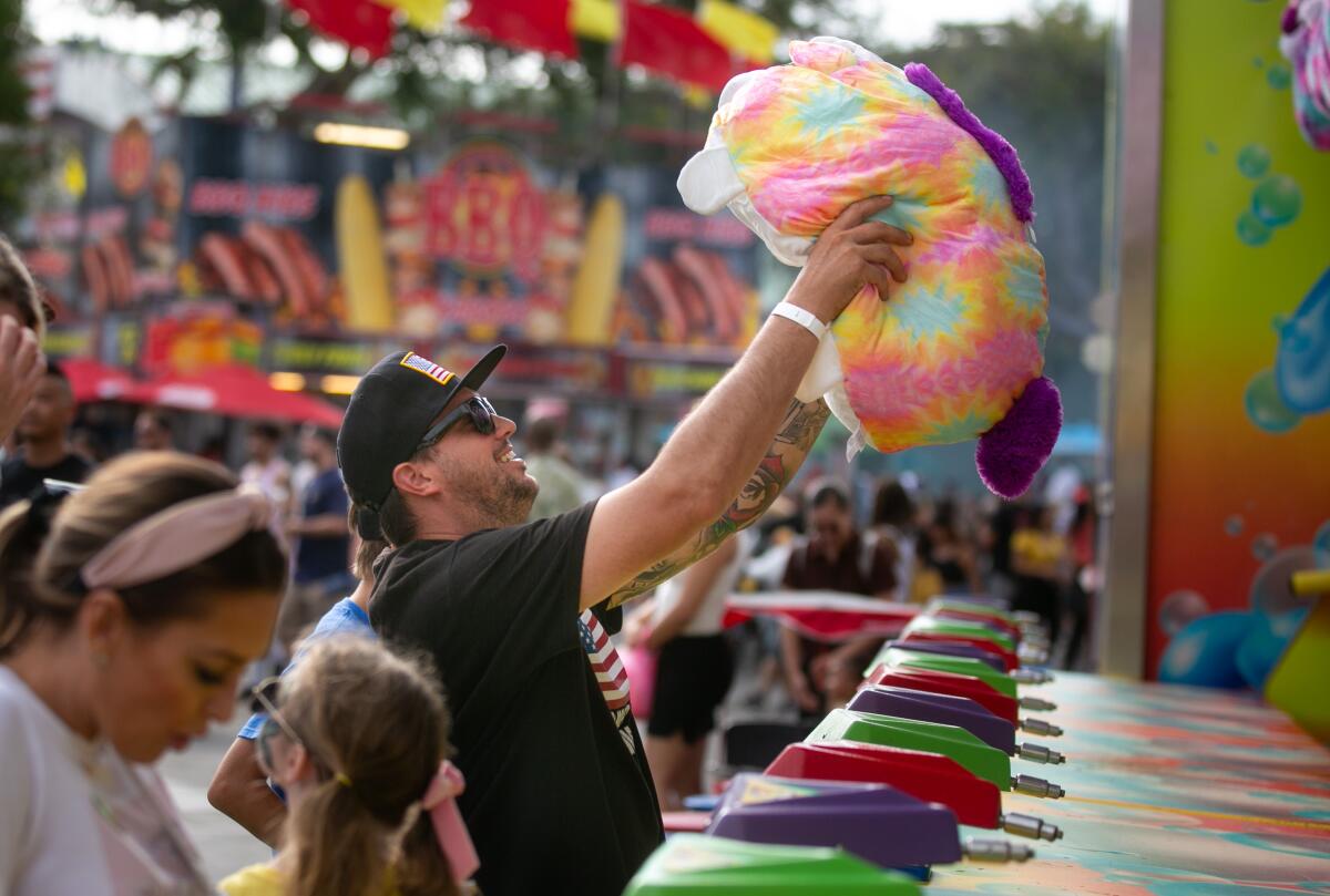 Chris Smith of Huntington Beach wins a stuffed animal at the Orange County Fair in July 2021.