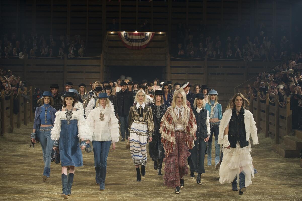 Models in fashion inspired by Native Americans, cowboys, and other Western tropes walk the runway during the Chanel "Metiers d'Art" show in Dallas.