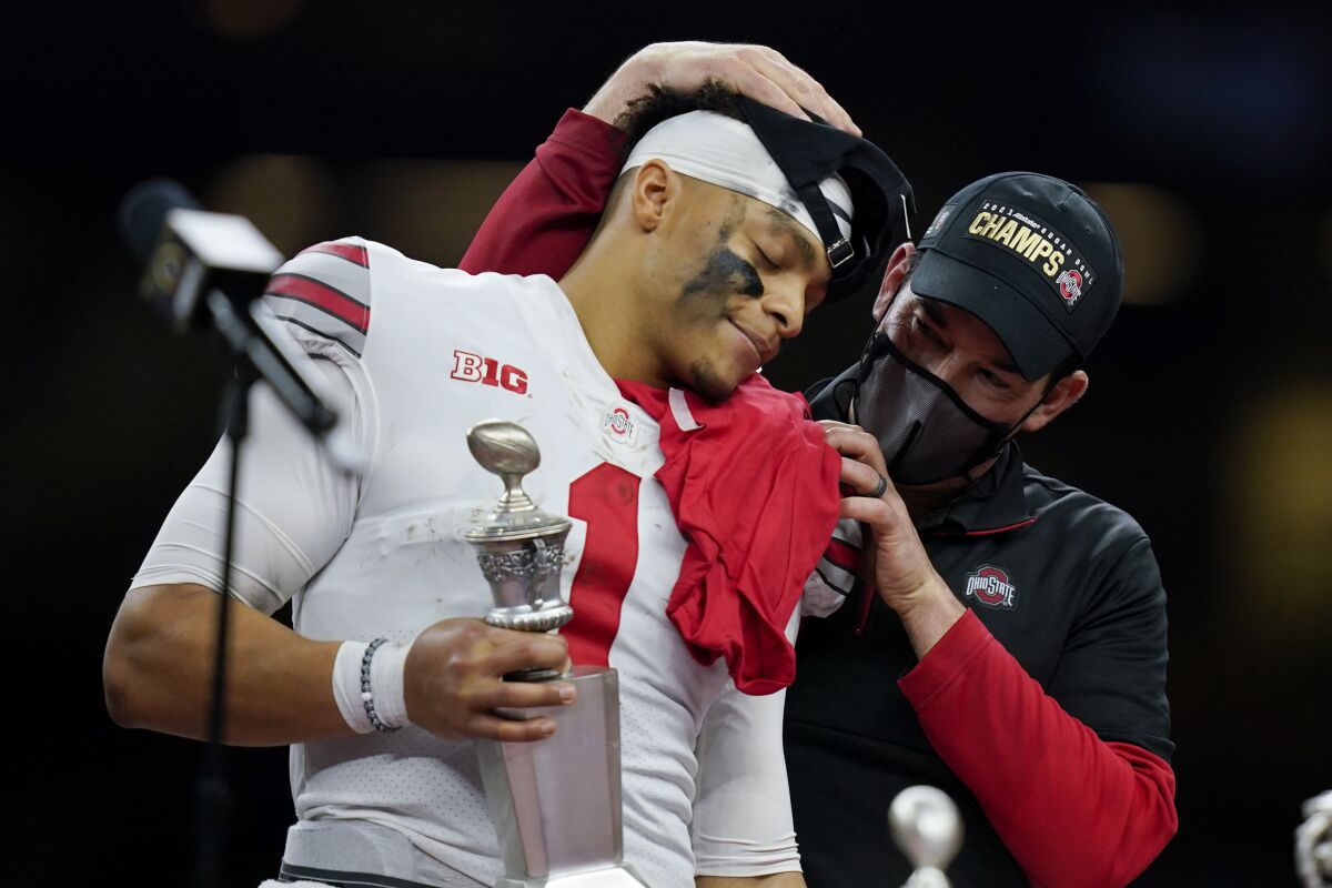 Ohio State head coach Ryan Day hugs quarterback Justin Fields after their win against Clemson in the Sugar Bowl NCAA college football game Friday, Jan. 1, 2021, in New Orleans. Ohio State won 49-28. (AP Photo/Gerald Herbert)