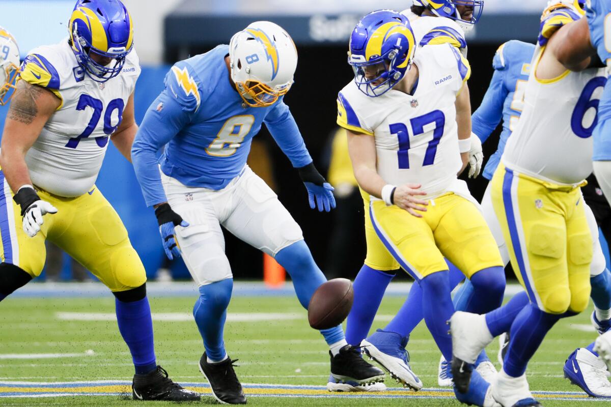 Chargers linebacker Kyle Van Noy (8) tries to pick up the ball after forcing a fumble on Rams quarterback Baker Mayfield.
