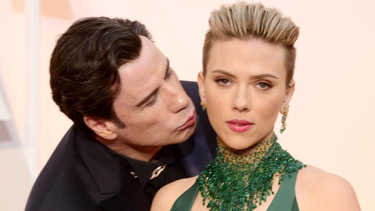 John Travolta kisses Scarlett Johansson as they arrive for the 87th Academy Awards ceremony at the Dolby Theatre in Hollywood on Feb. 22, 2015. The Oscars are presented for outstanding individual or collective efforts in 24 categories in filmmaking. EPA/MIKE NELSON ** Usable by LA, CT and MoD ONLY **