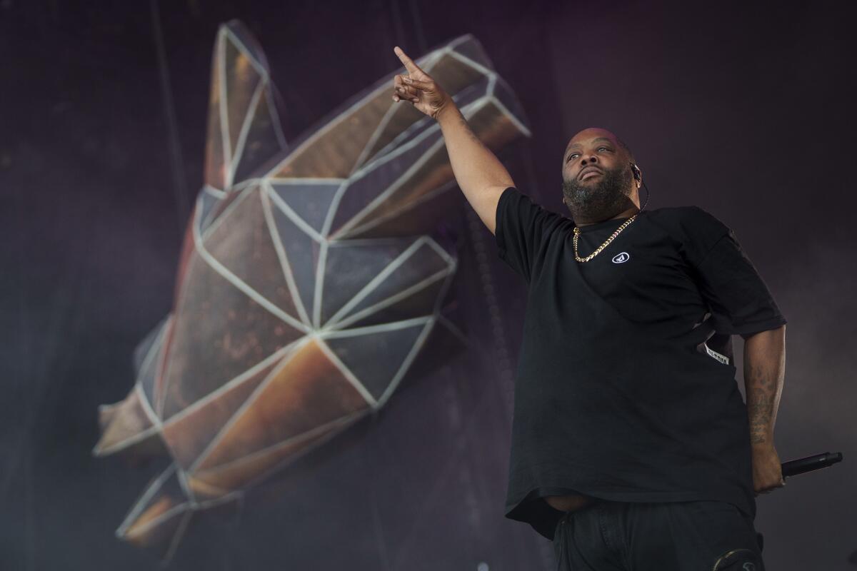 Killer Mike of Run the Jewels points his right index finger in the air while performing onstage