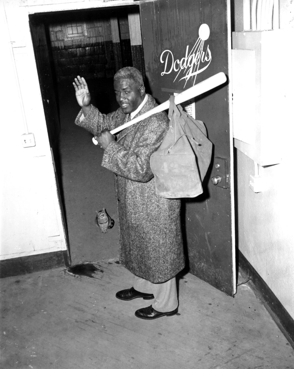 Jackie Robinson waves as he leaves the clubhouse after collecting his belongings at Ebbets Field.