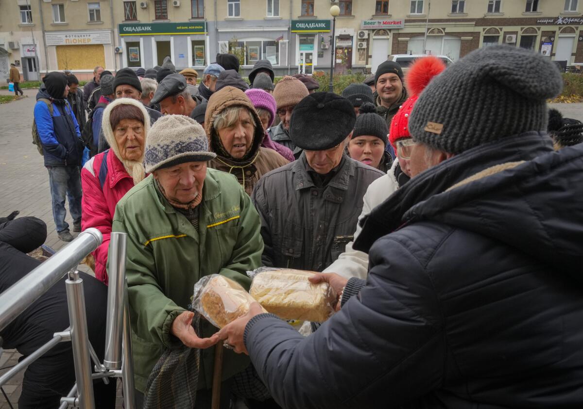 Local residents stand in line waiting for free bread.