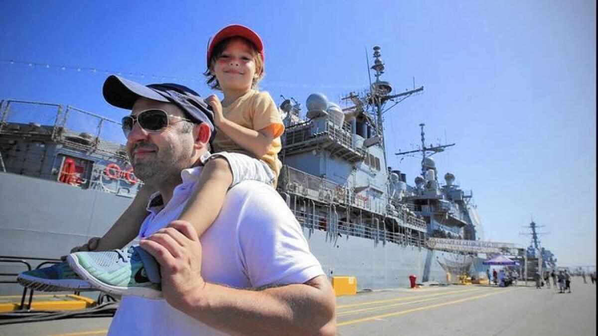Daimhin Murphy y su hijo Gavin pasan junto al Cape St. George, uno de los tres barcos abiertos al público durante la ‘Semana de la Flota’ de San Diego, el año pasado.