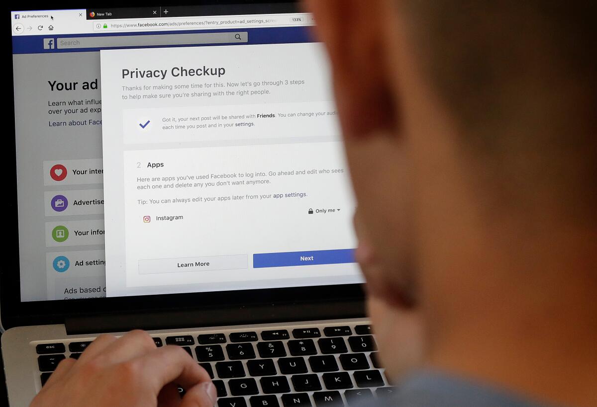 Person looks at laptop screen displaying Facebook privacy options