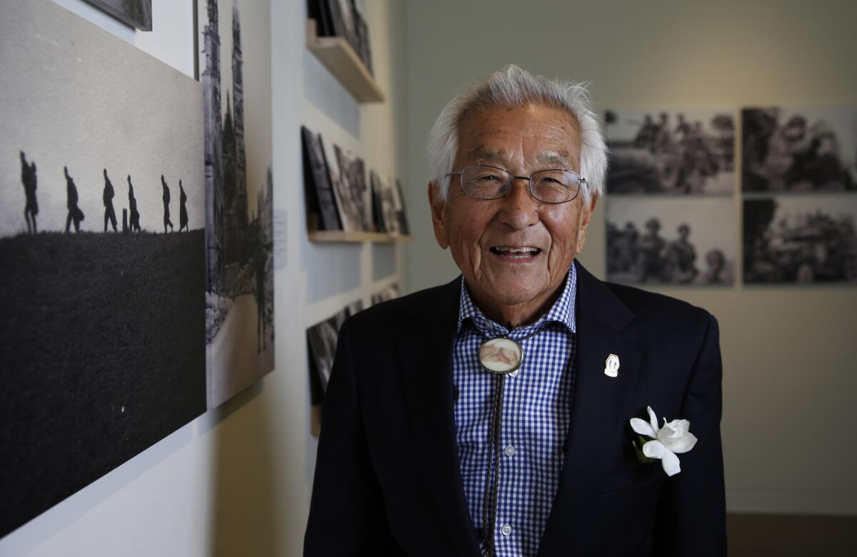 Sus Ito stands before his exhibit, "Before They Were Heroes: Sus Ito's World War II Images," at the Japanese American National Museum in Los Angeles. Ito, 95, served in the segregated Japanese American 442nd Regiment during World War II and took pictures of life on the front.