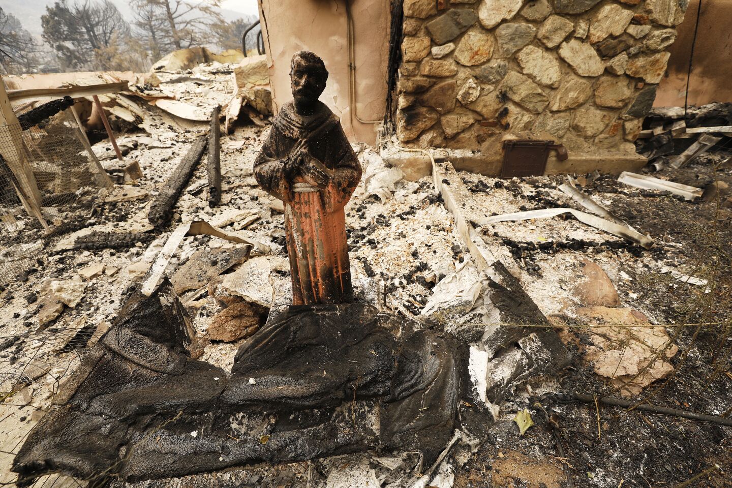 A scorched statue stands in front of a home on Pine Canyon Road destroyed by fire along Pine Canyon in the Lake Hughes area.