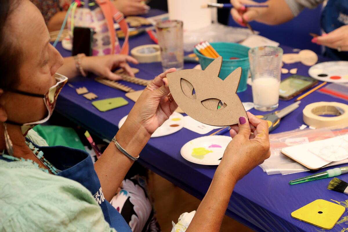 A participant works on a Mika the Cat clock during a character clock-building workshop at Laguna Art Museum.
