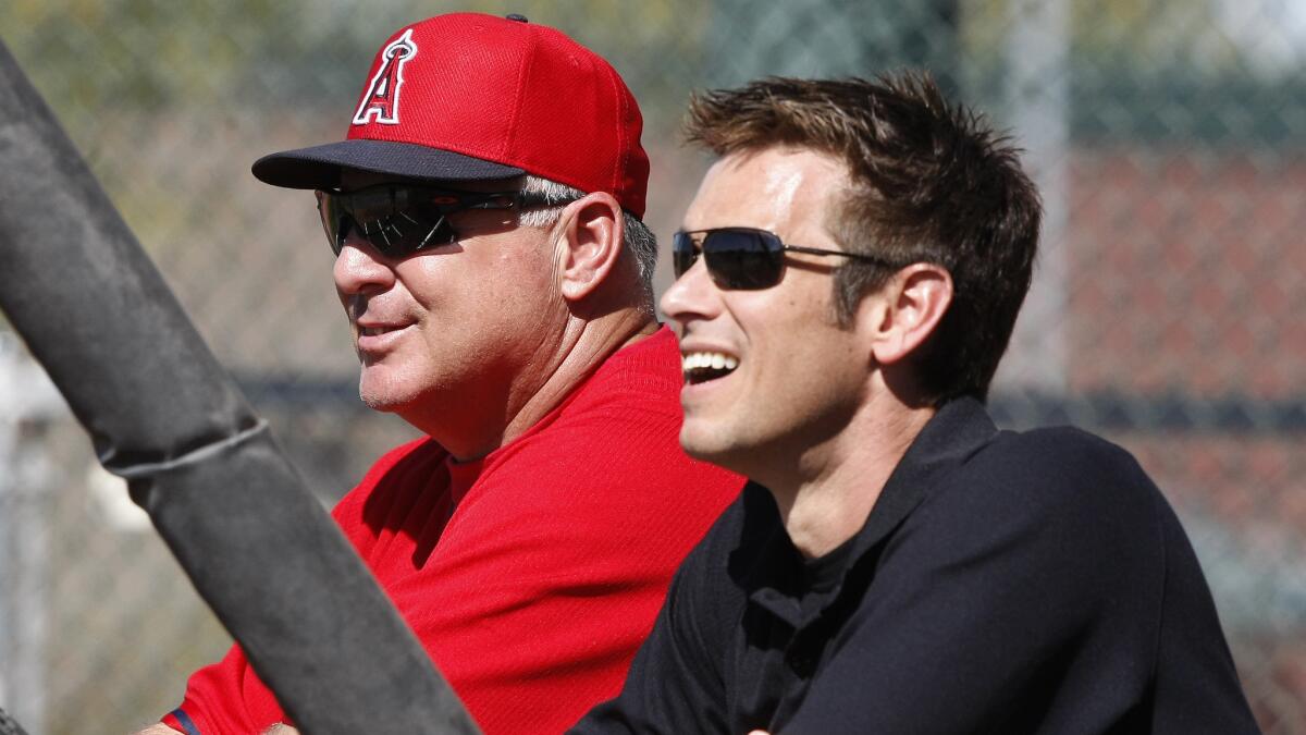 Angels Manager Mike Scioscia, left, and General Manager Jerry Dipoto watch batting practice during spring training.