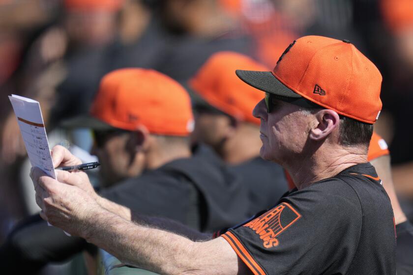 San Francisco Giants manager Bob Melvin takes notes during the fifth inning of a spring training baseball game against the Oakland Athletics Saturday, March 9, 2024, in Scottsdale, Ariz. (AP Photo/Ross D. Franklin)