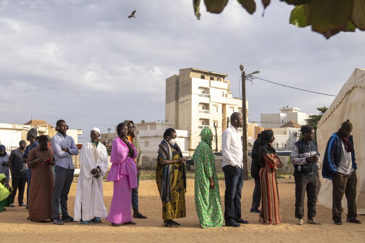 People wait to cast their votes outside a polling station during the presidential elections, in Dakar, Senegal, Sunday, March 24, 2024. (AP Photo/Mosa'ab Elshamy)
