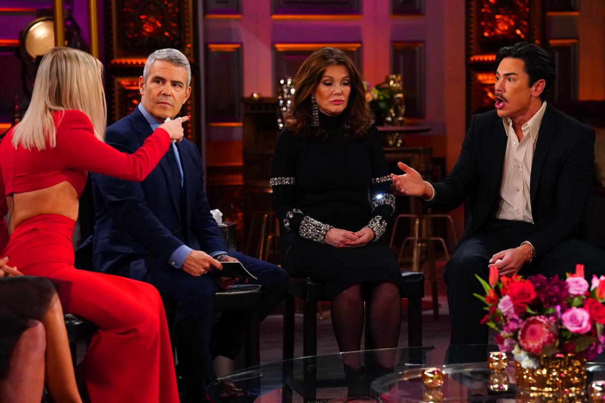 Ariana Madix points at Tom Sandoval, with Andy Cohen and Lisa Vanderpump sitting between them.