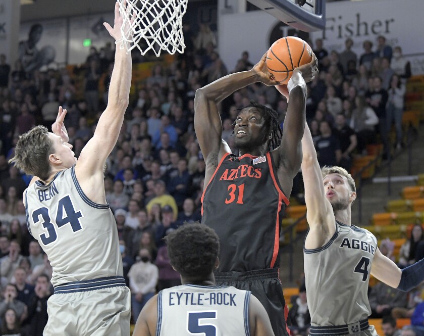 SDSU senior Nathan Mensah goes up to dunk the ball against Utah State's Justin Bean (34) for two of his four points.
