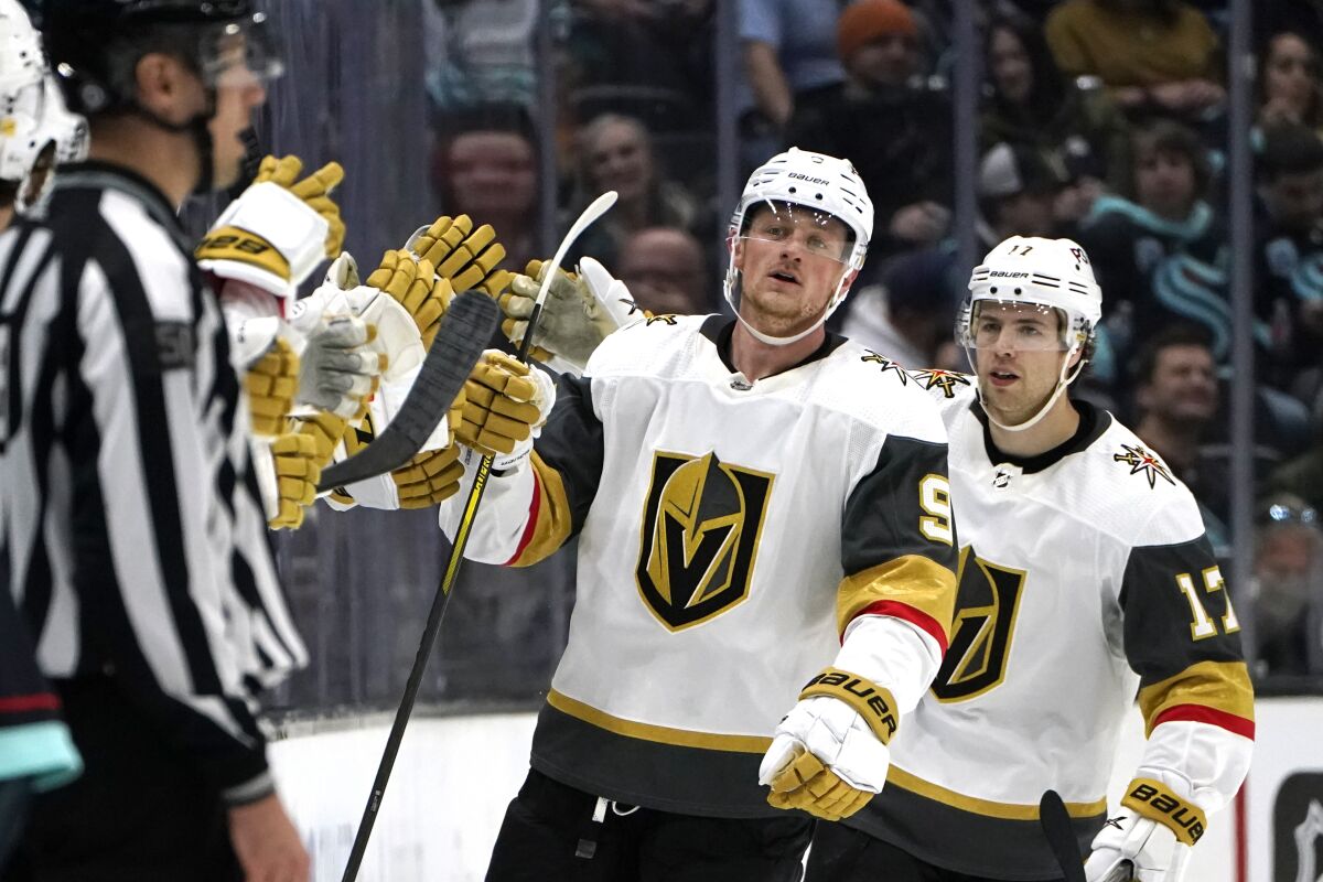 Vegas Golden Knights' Jack Eichel (9) is congratulated after scoring against the Seattle Kraken as teammate Ben Hutton follows in the second period of an NHL hockey game Friday, April 1, 2022, in Seattle. (AP Photo/Elaine Thompson)
