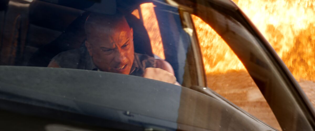 Vin Diesel drives a car with a fire burning behind him in "Fast X."