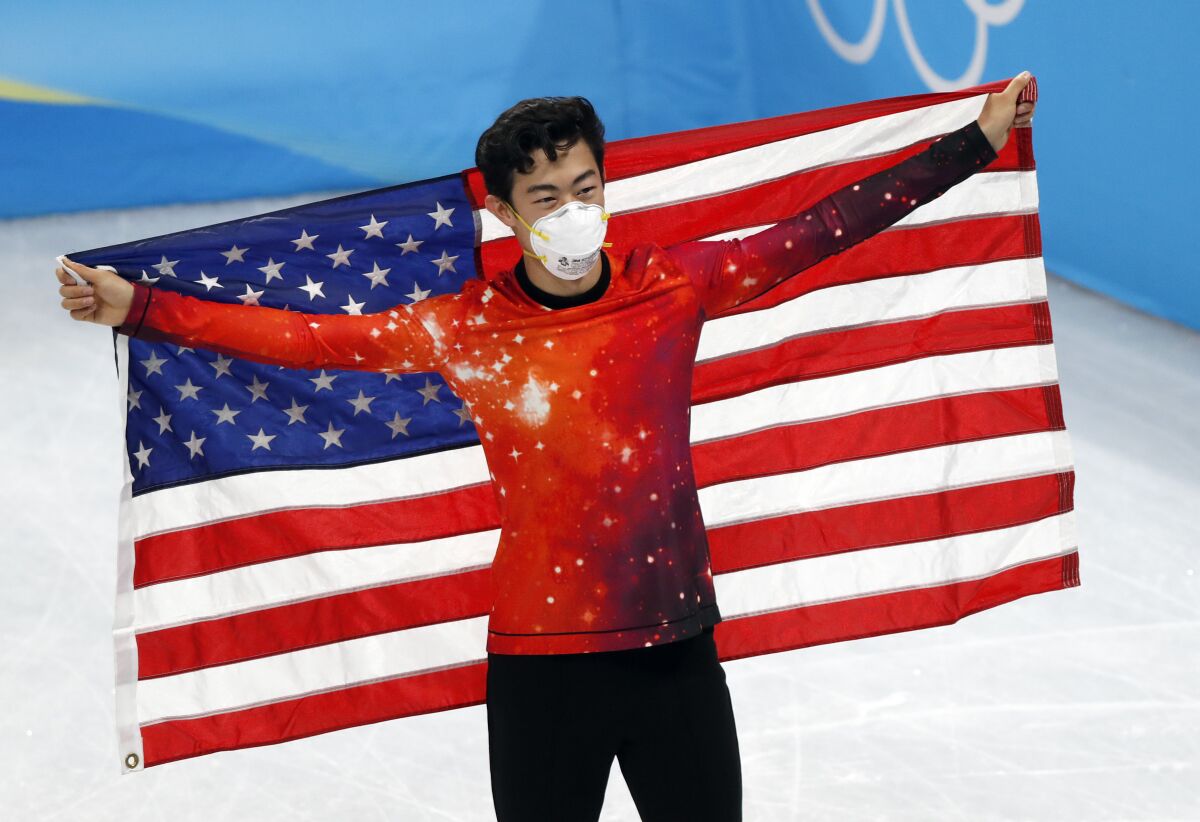 Nathan Chen celebrates with an American flag after winning the gold medal.