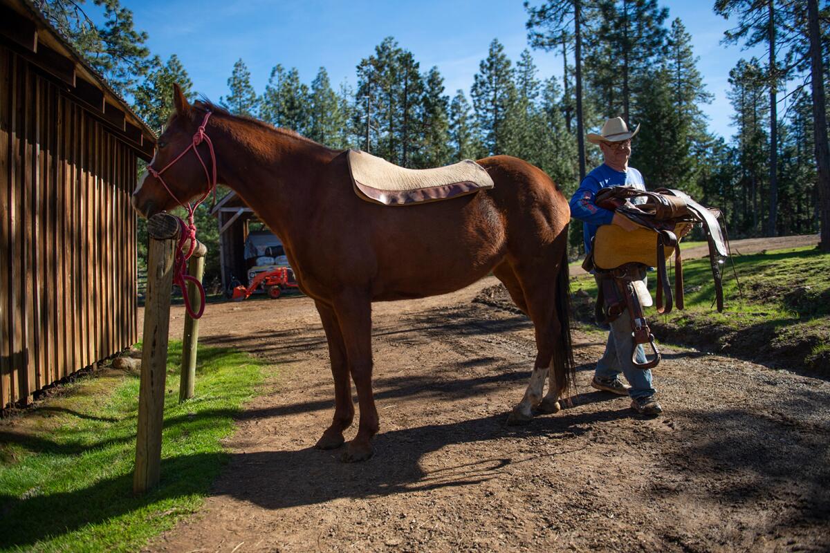Jim Gund saddles his horse in the remote community of Kettenpom in Trinity County