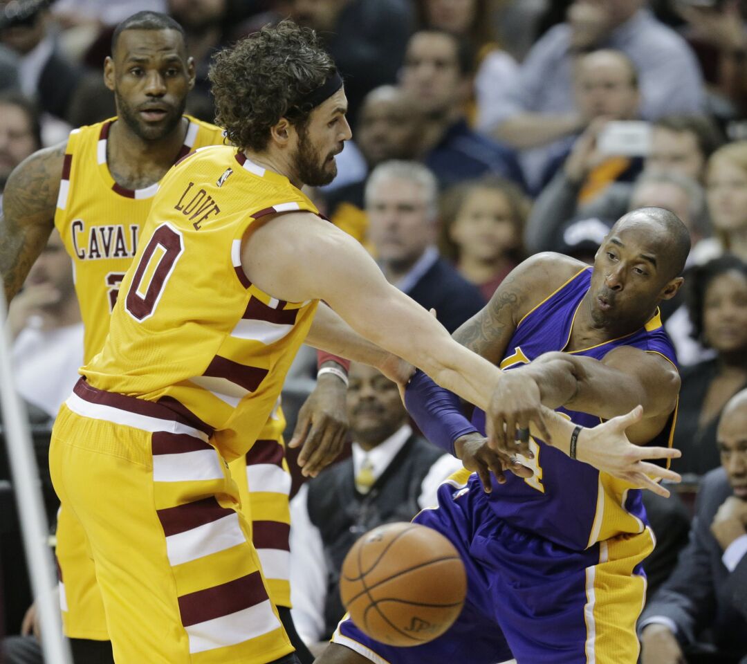 Kobe Bryant passes around Cleveland forward Kevin Love during the first half of a game on Feb. 10.
