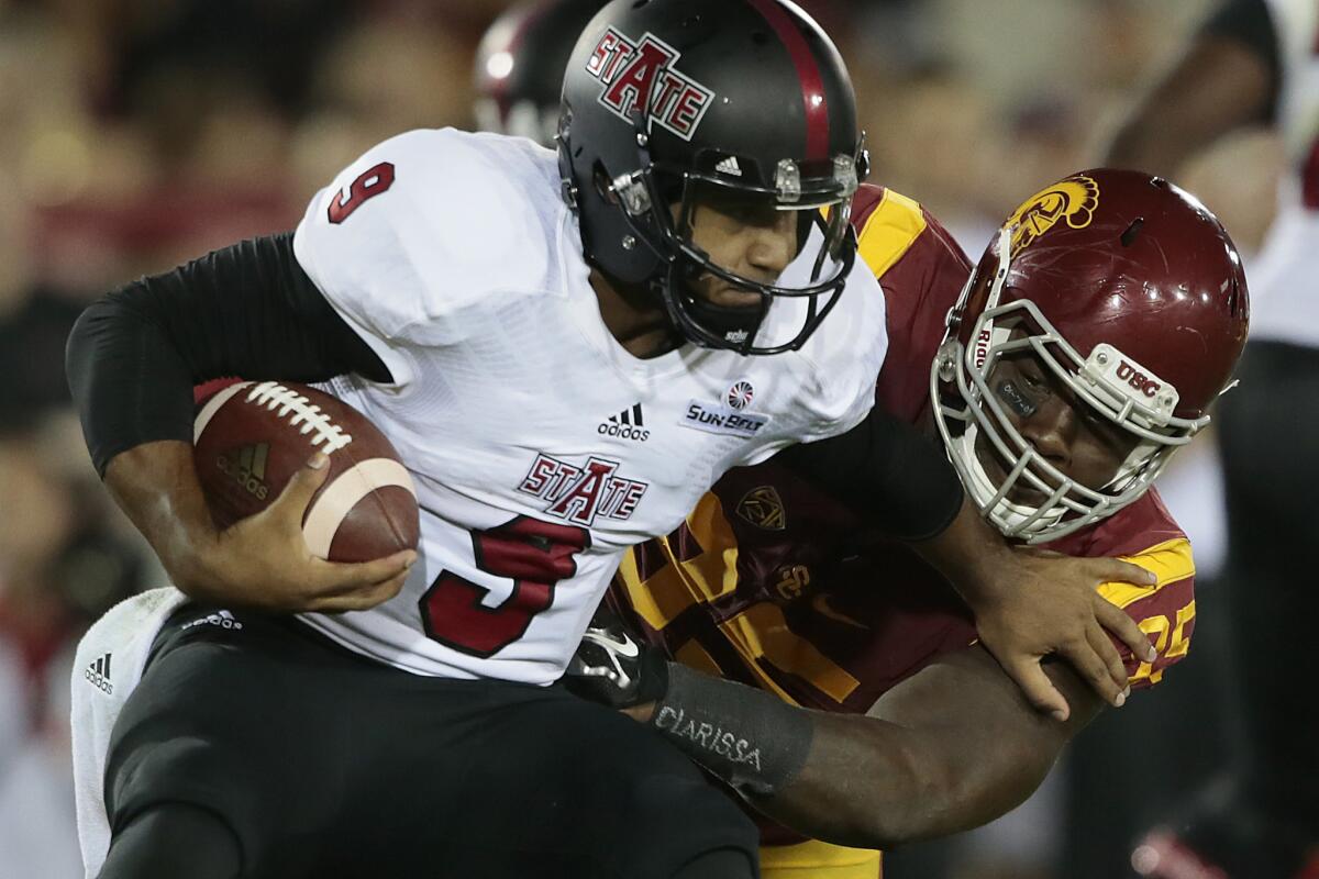 USC defensive tackle Kenny Bigelow Jr. sacks Arkansas State quarterback Fredi Knighten in the first half of a game Sept. 5, 2015.