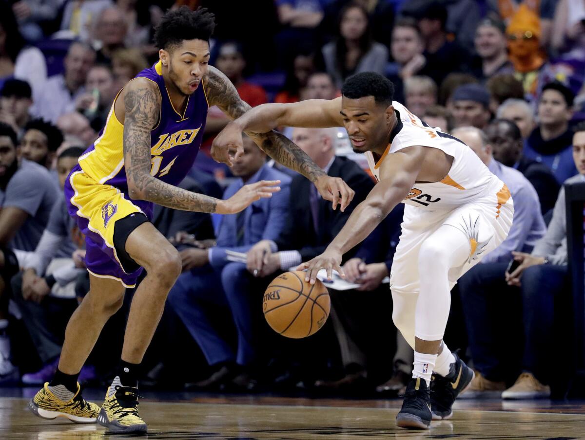 Suns forward T.J. Warren and Lakers forward Brandon Ingram reach for the ball during the first half of a game on Thursday.