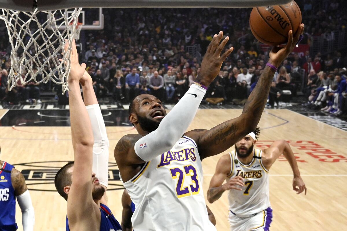 Los Angeles Lakers forward LeBron James, right, shoots as Los Angeles center Ivica Zubac defends during the first half of an NBA basketball game Sunday, March 8, 2020, in Los Angeles. (AP Photo/Mark J. Terrill)