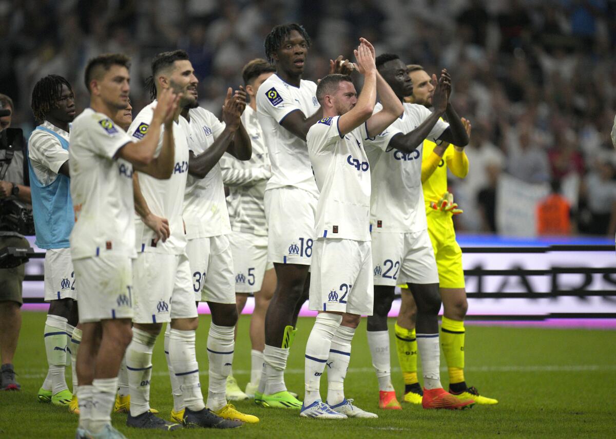 Marseille players applaud supporters at the end of the French League One soccer match between Olympique de Marseille and Lille at the Velodrome stadium in Marseille, southern France, Saturday, Sept. 10, 2022. (AP Photo/Daniel Cole)