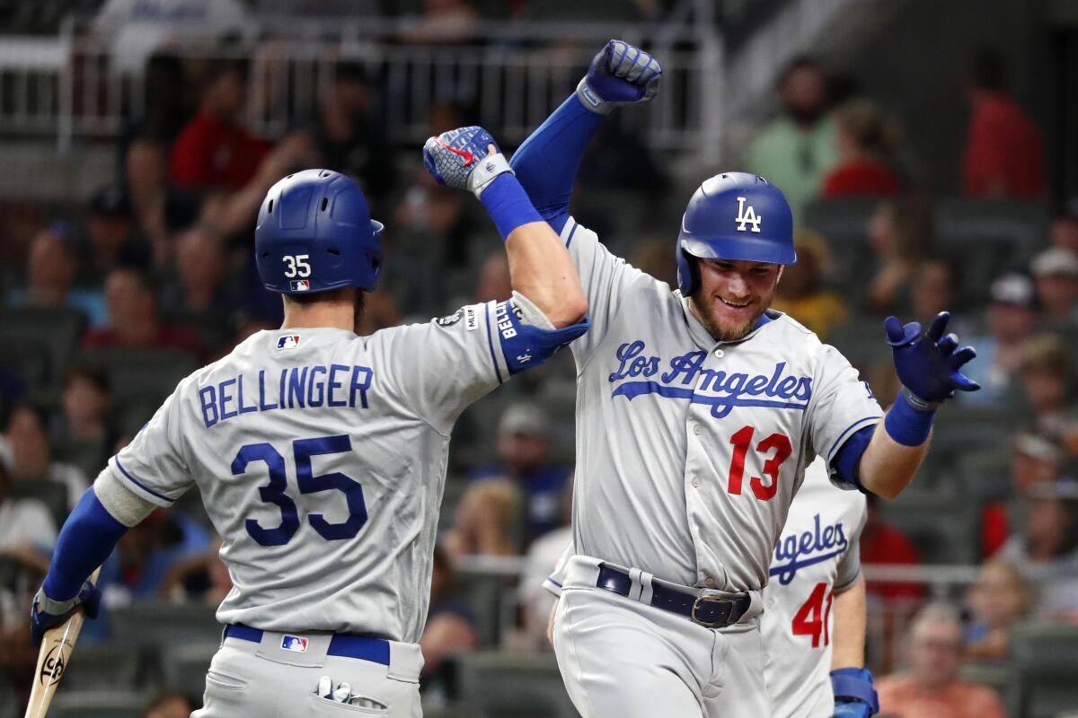 Dodgers' Max Muncy (13) celebrates with Cody Bellinger (35) after hitting a three-run home in the seventh inning against the Atlanta Braves on Friday in Atlanta. 