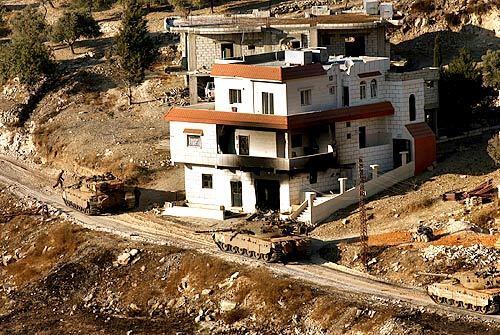 In the town of Ainata, Israeli tanks retreat from their position after recovering a damaged tank. Ainata is filled with large homes, many which are vacation homes.