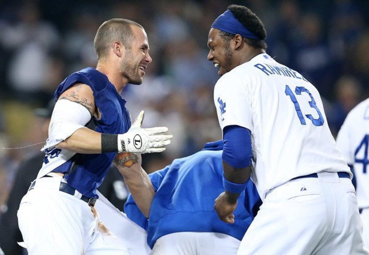 Dodgers shortstop Hanley Ramirez, right, celebrates with pinch-runner Skip Schumaker, who scored the winning run in the 10th inning Friday night against the Braves.