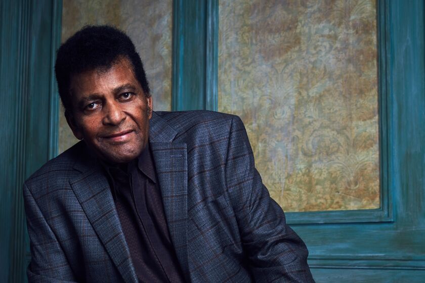 Charley Pride dons a blue jacket and tie in a formal portrait