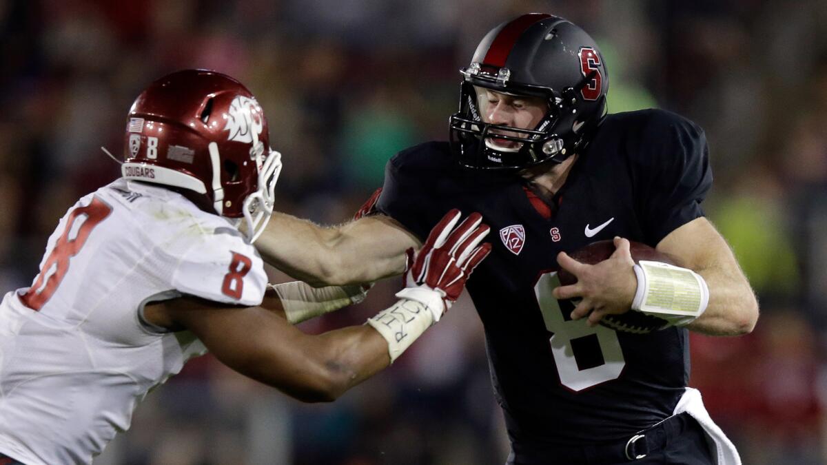 Stanford quarterback Kevin Hogan, right, tries to fend off Washington State linebacker Jeremiah Allison during the Cardinal's 34-17 win Friday.